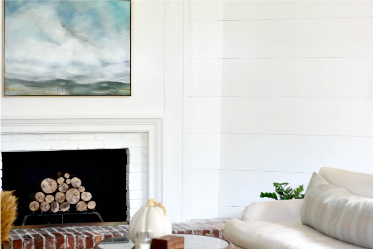 white fireplace with small mantle and shiplap