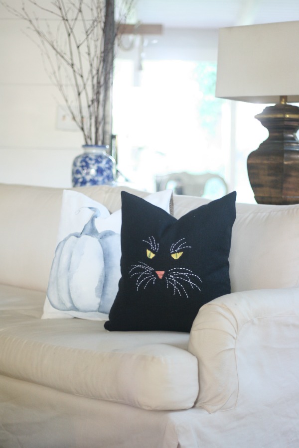 black cat pillow with pumpkin